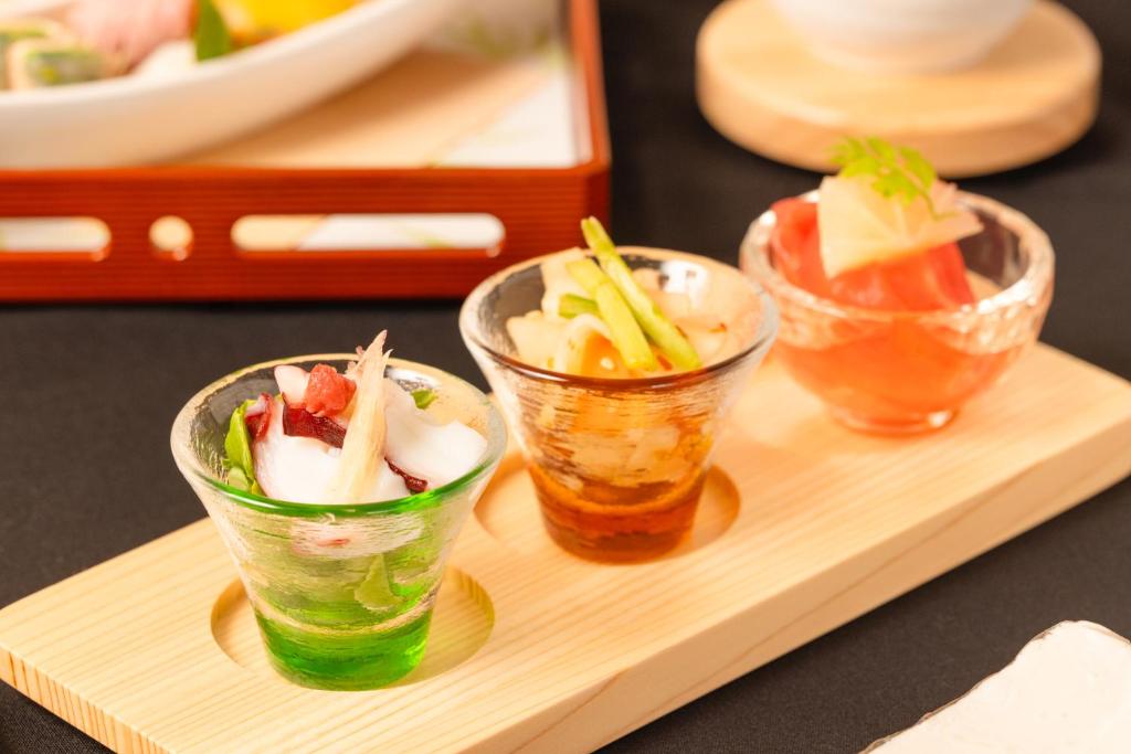 trois petits bols de nourriture sur un plateau en bois dans l'établissement 奥州平泉温泉旅館 itsumu, à Oshu