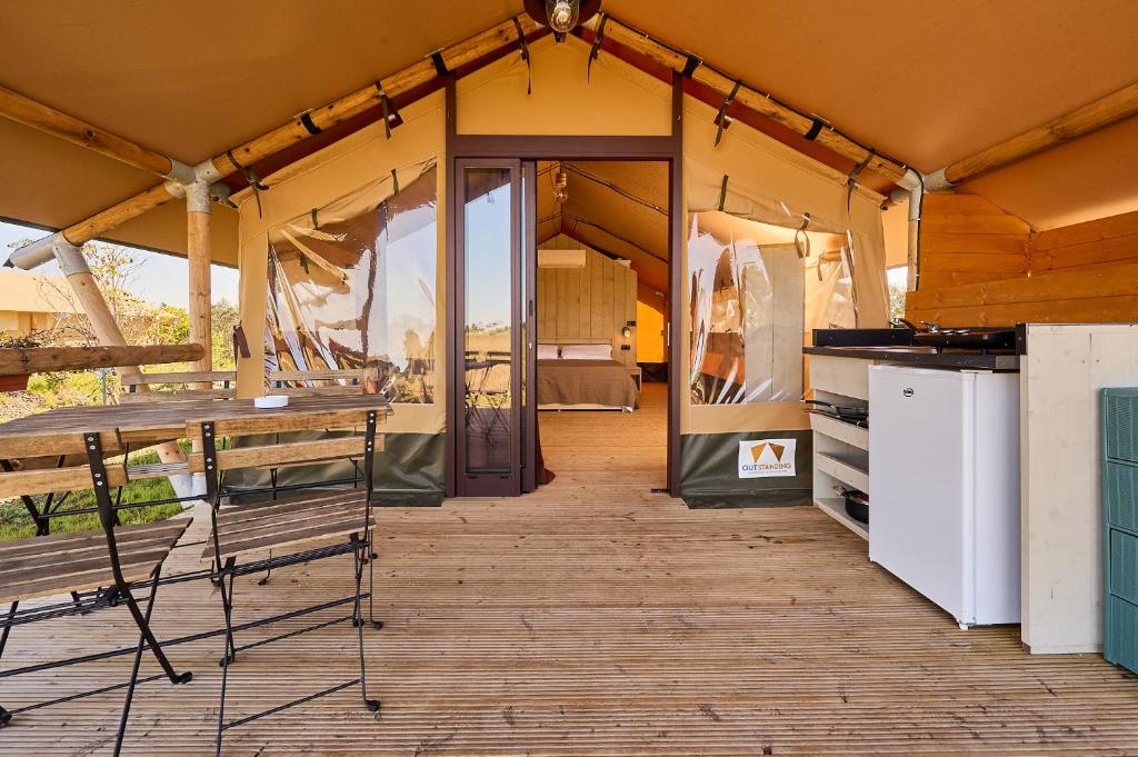 une tente avec une table et des chaises à l'intérieur dans l'établissement Delfino Tuscany Resort, à Marina di Cecina