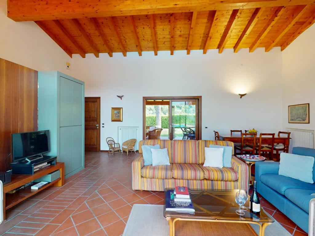 un salon avec un canapé et une télévision dans l'établissement Villa Paradiso by Bookinggardalake, à San Felice del Benaco