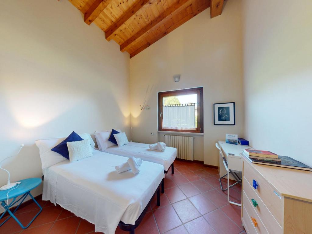 une chambre avec deux lits et une table et une fenêtre dans l'établissement Villa Paradiso by Bookinggardalake, à San Felice del Benaco
