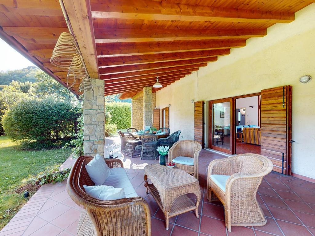une terrasse avec des chaises et des tables en osier sur une maison dans l'établissement Villa Paradiso by Bookinggardalake, à San Felice del Benaco