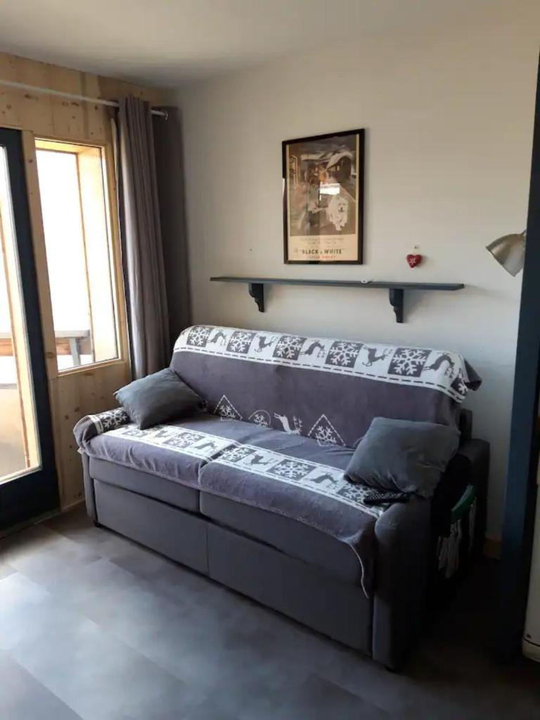 d'un salon avec un canapé et une fenêtre. dans l'établissement Appartement Tilia - Avoriaz, à Avoriaz