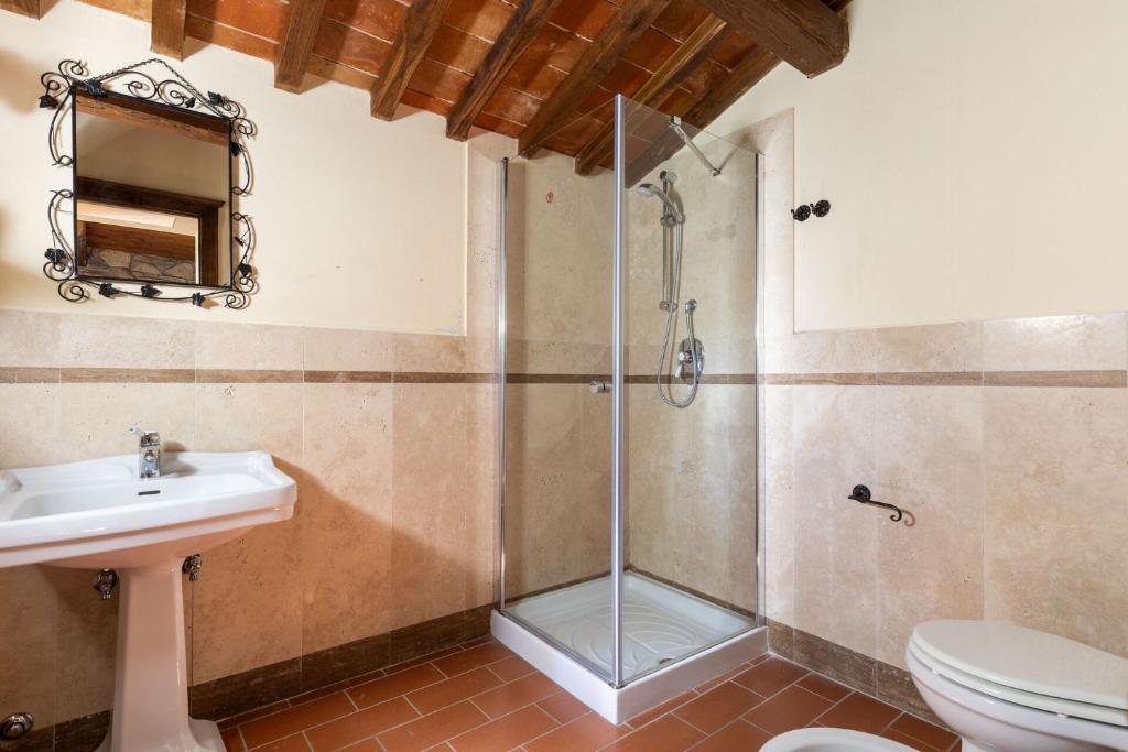 une salle de bain avec une douche avec un lavabo et des toilettes dans l'établissement Villa Casentino by PosarelliVillas, à Capolona