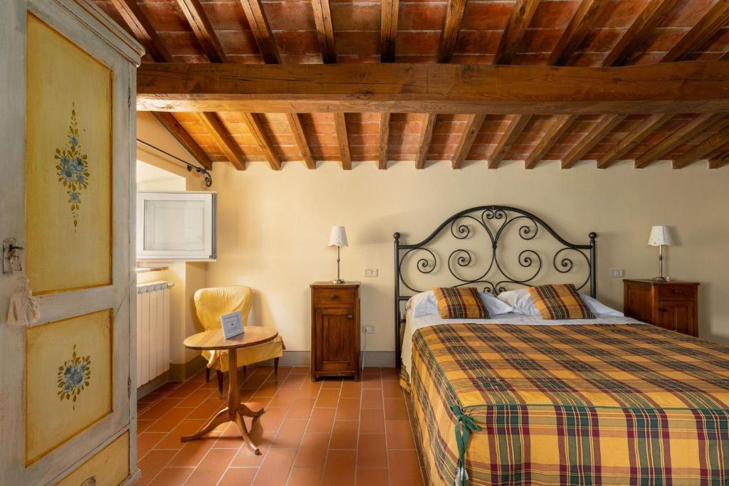 une chambre avec un lit, une table et une chaise dans l'établissement Villa Casentino by PosarelliVillas, à Capolona 42 autres photos