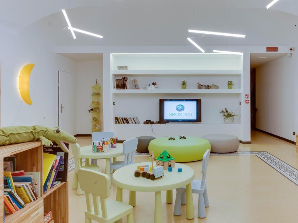 Cette chambre dispose de tables, de chaises et d'une télévision. dans l'établissement Hotel Medusa, à Finale Ligure 162 autres photos