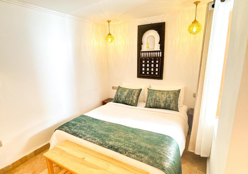 - une chambre avec un lit blanc et des oreillers verts dans l'établissement Riad Dar Timrad, à Fès 37 autres photos