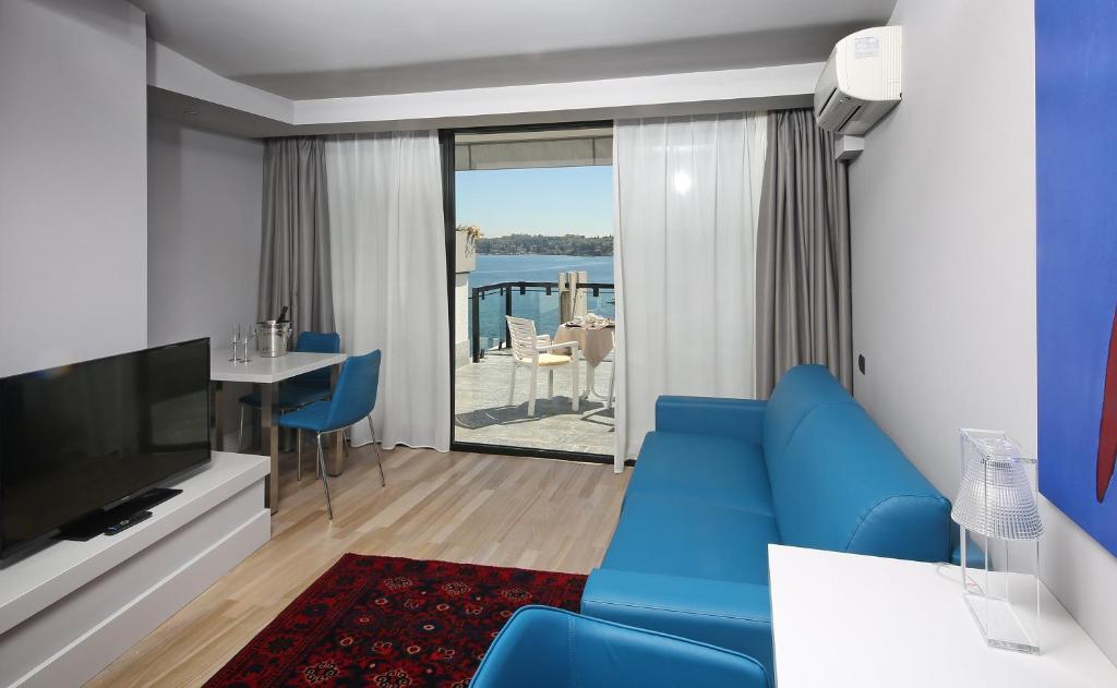 un salon avec un canapé bleu et une télévision dans l'établissement Hotel Salò du Parc, à Salò