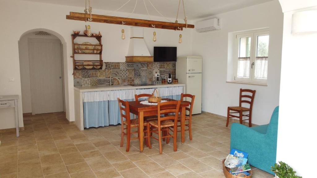 une cuisine et une salle à manger avec une table et des chaises dans l'établissement Antichi Saperi - Villa con piscina Cisternino, à Cisternino