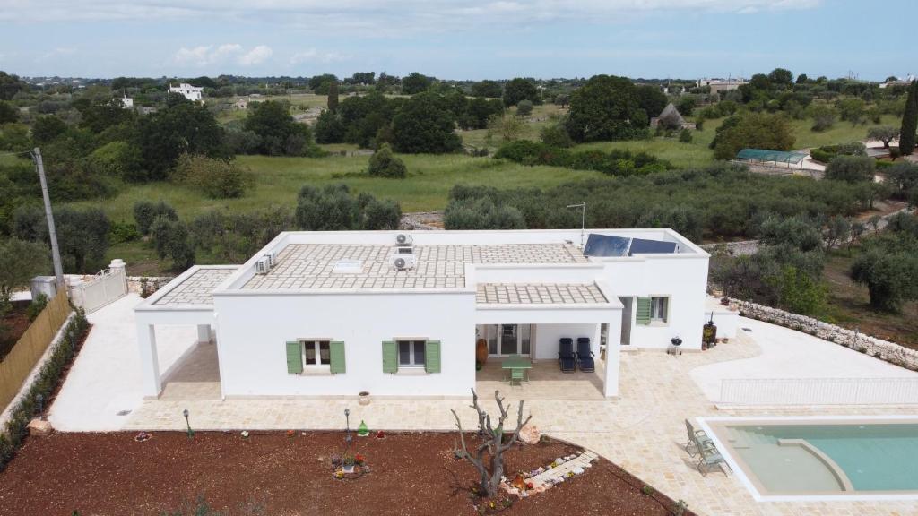 une vue aérienne d'une maison blanche avec piscine dans l'établissement Antichi Saperi - Villa con piscina Cisternino, à Cisternino