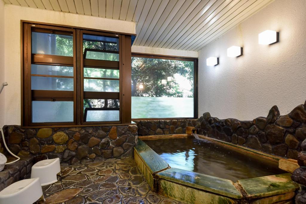 une grande pièce avec une baignoire au milieu d'une salle de bain dans l'établissement Bijintei, à Tanabe 31 autres photos