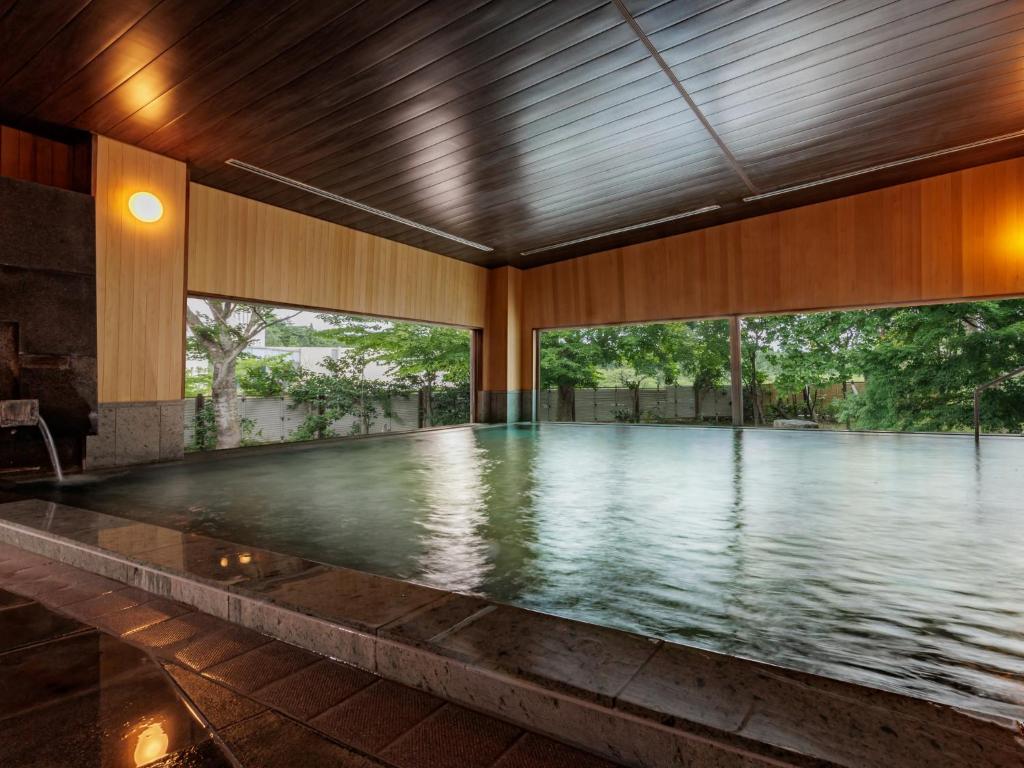 - une piscine vide dans un bâtiment avec fenêtres dans l'établissement KAMENOI HOTEL Aomori Makado, à Noheji