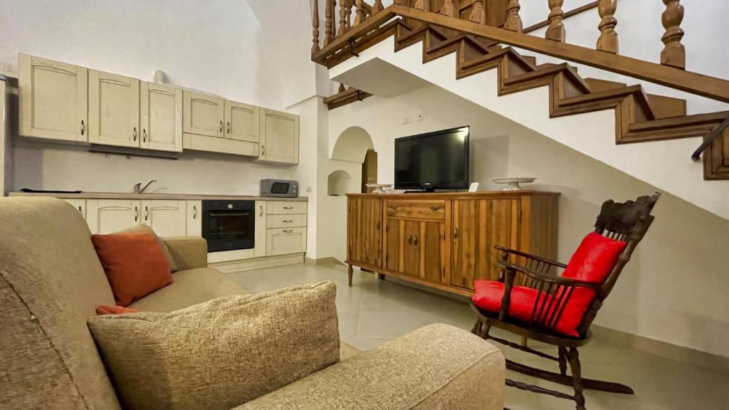 un salon avec un canapé et une télévision dans l'établissement La Corte di Leuca Residence, à Leuca