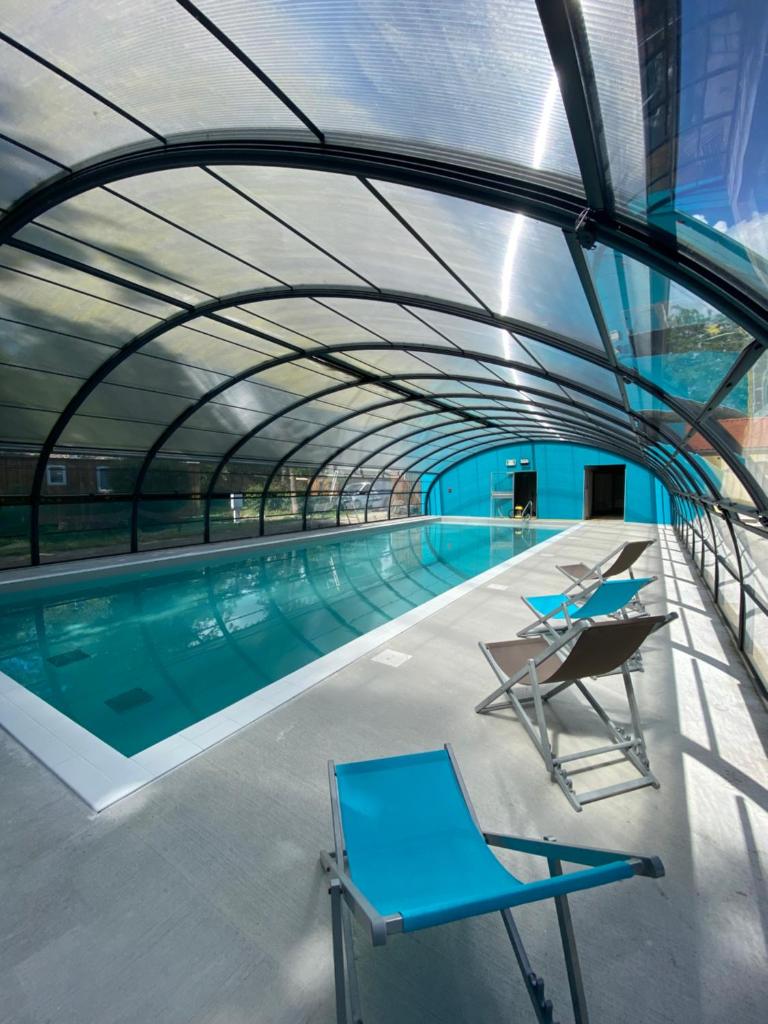 une piscine intérieure avec un plafond en verre dans l'établissement Camping du Chêne, à Saint-Julien-de-Concelles