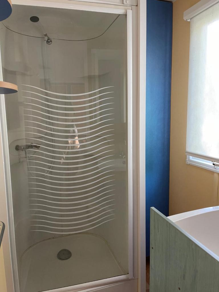 une douche avec une porte vitrée dans une salle de bain dans l'établissement Camping L Eden Road, à Castellane 37 autres photos