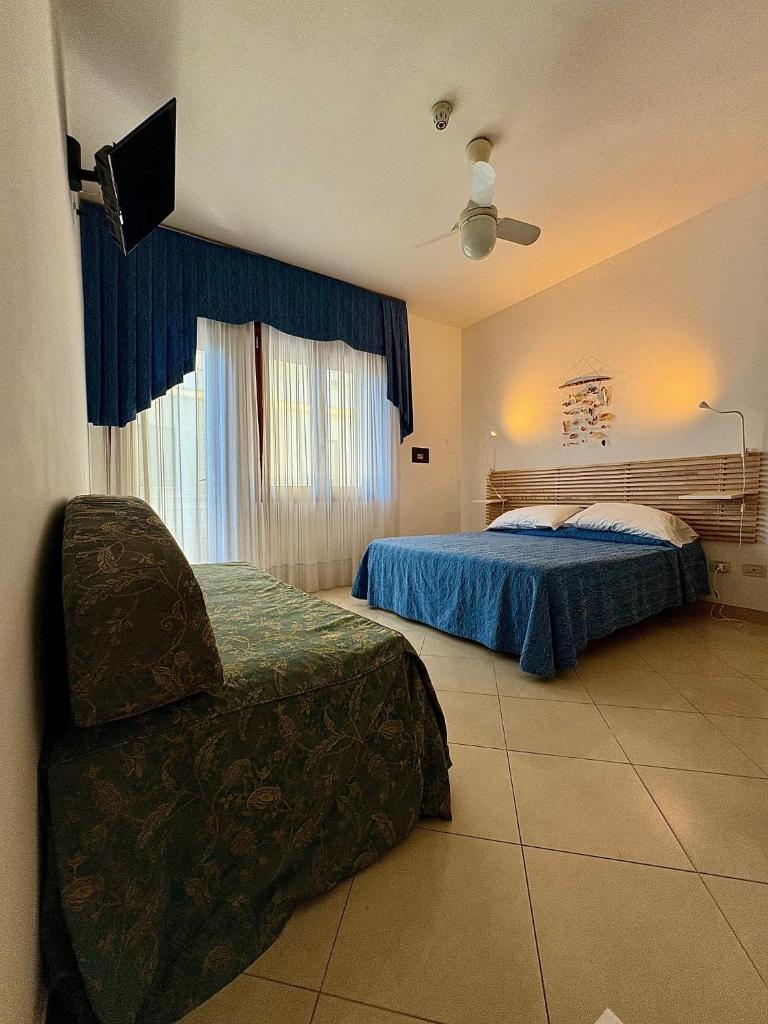 - une chambre avec 2 lits et une chaise dans l'établissement Hotel Fortuna, à Chioggia