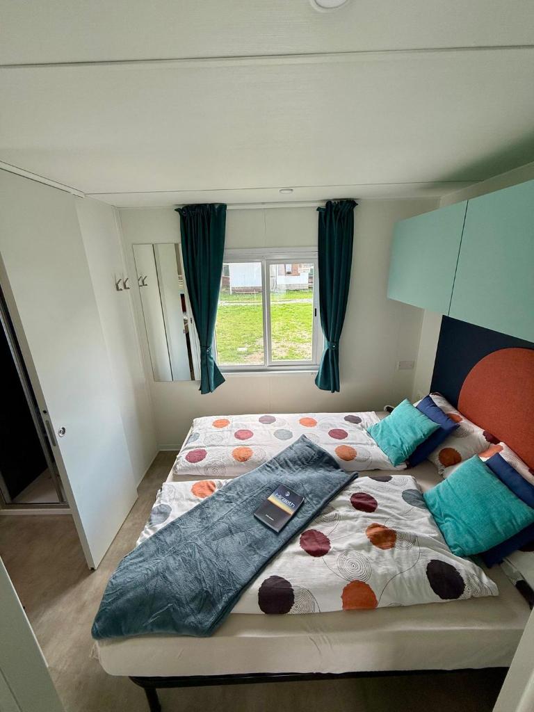 une chambre avec un grand lit avec une fenêtre dans l'établissement Bungalow Lido MAREA, direkt at the lake & in center, à Colico