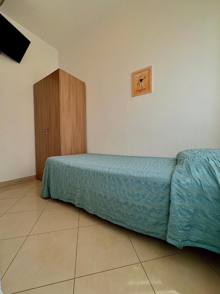 une chambre avec un lit et une armoire en bois dans l'établissement Hotel Fortuna, à Chioggia