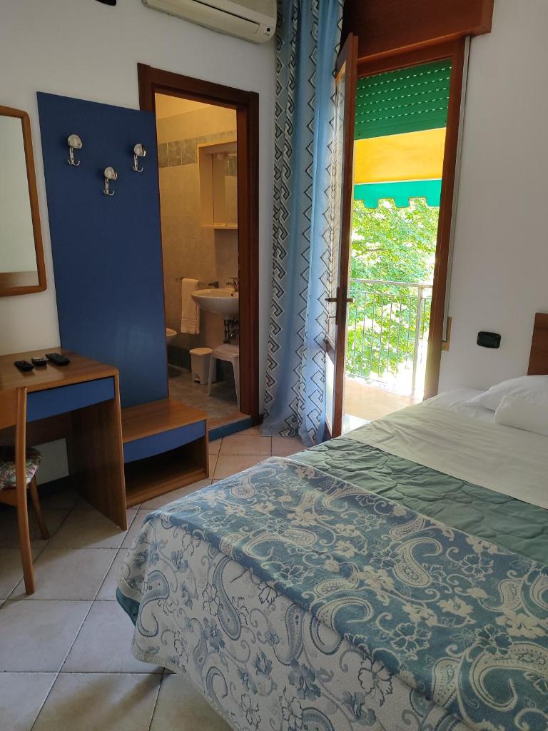 une chambre avec un lit et une salle de bain avec une fenêtre dans l'établissement Hotel Trifoglio, à Lido di Jesolo