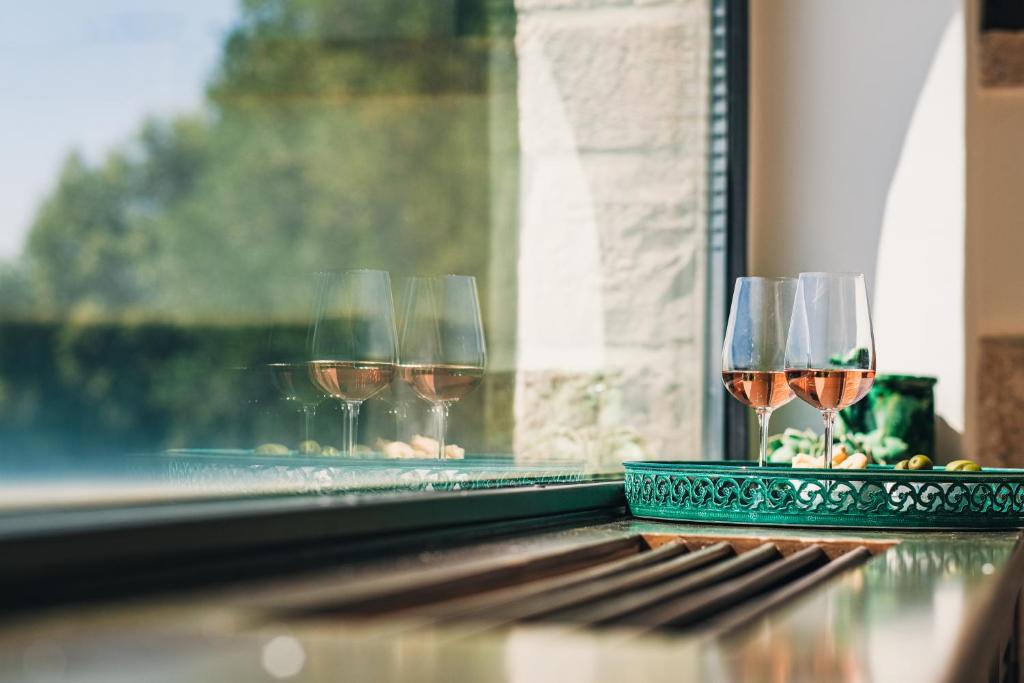 trois verres de vin assis sur un rebord de fenêtre dans l'établissement HelloAPULIA - Masseria Minetta, Scenic Villa Escape - Pet friendly, à Cisternino 55 autres photos