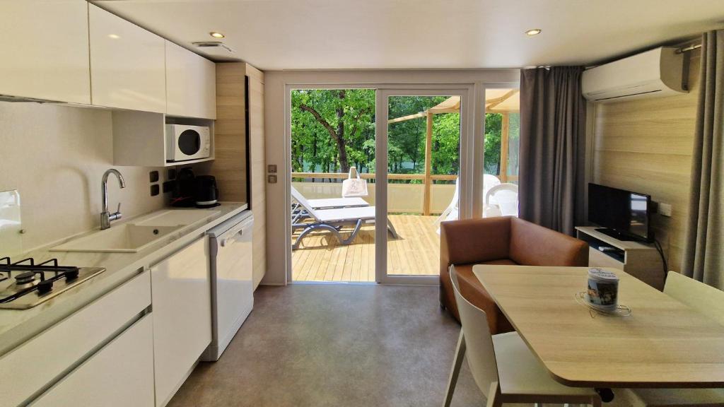 une cuisine et un salon avec une table et une salle à manger dans l'établissement Camping Naturiste Tikayan Petit Arlane, à Valensole