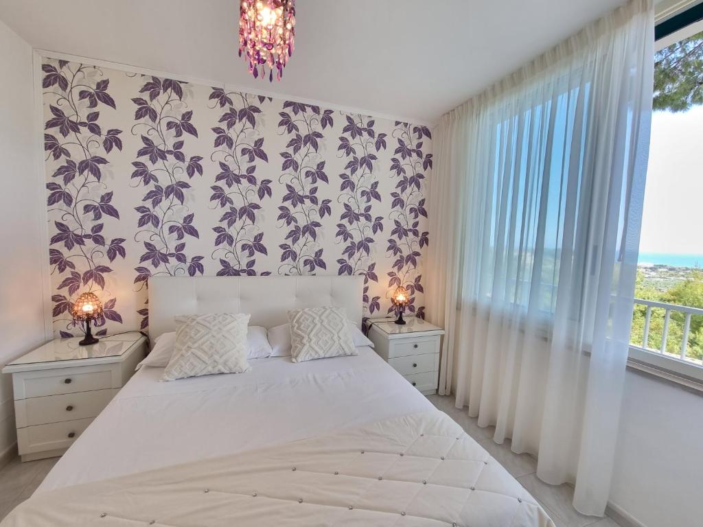 une chambre avec un grand lit blanc et une fenêtre dans l'établissement Residence Maresol, à Vieste 78 autres photos