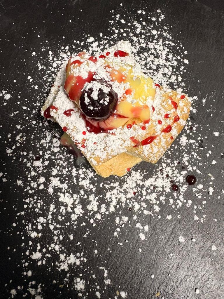 un morceau de nourriture avec du sucre en poudre sur une table dans l'établissement Luxury Resort, à Licola