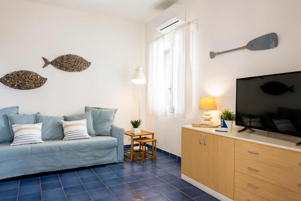 un salon avec un canapé bleu et une télévision à écran plat dans l'établissement Villa Vulcano, à Marina di Ragusa