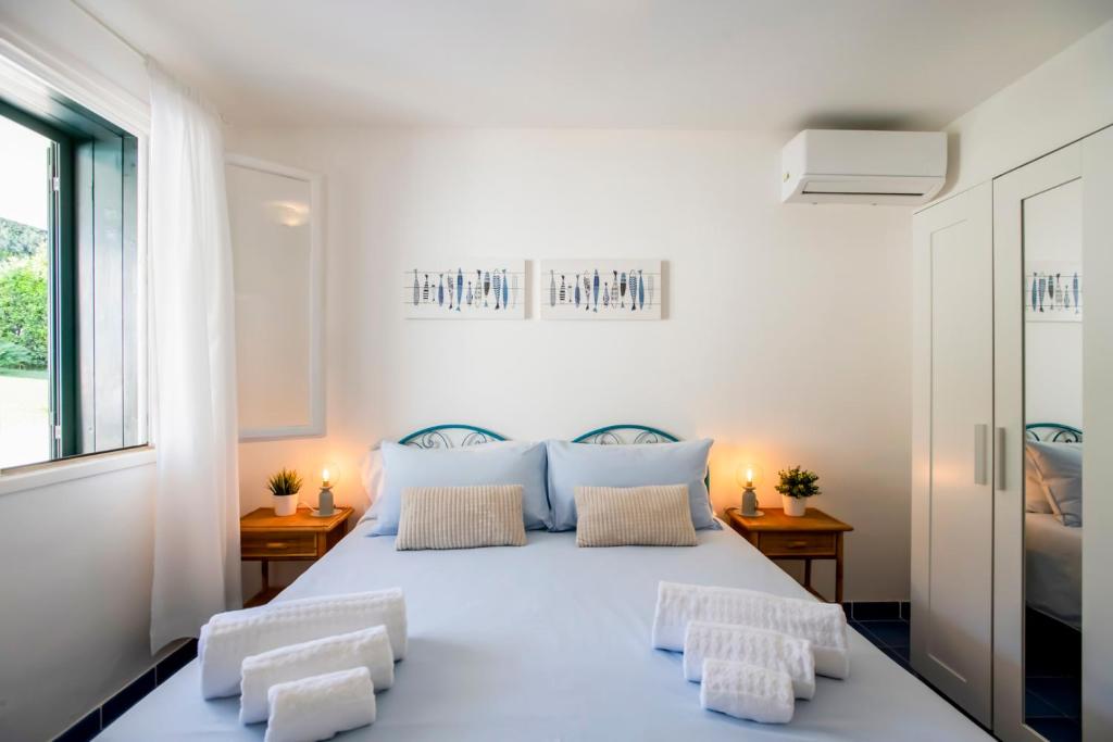 une chambre avec un grand lit blanc avec deux chaises dans l'établissement Villa Vulcano, à Marina di Ragusa 23 autres photos