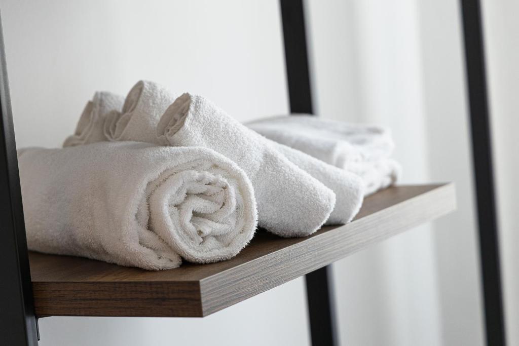 une pile de serviettes assises sur une étagère en bois dans l'établissement Hotel Levante Cesenatico, à Cesenatico