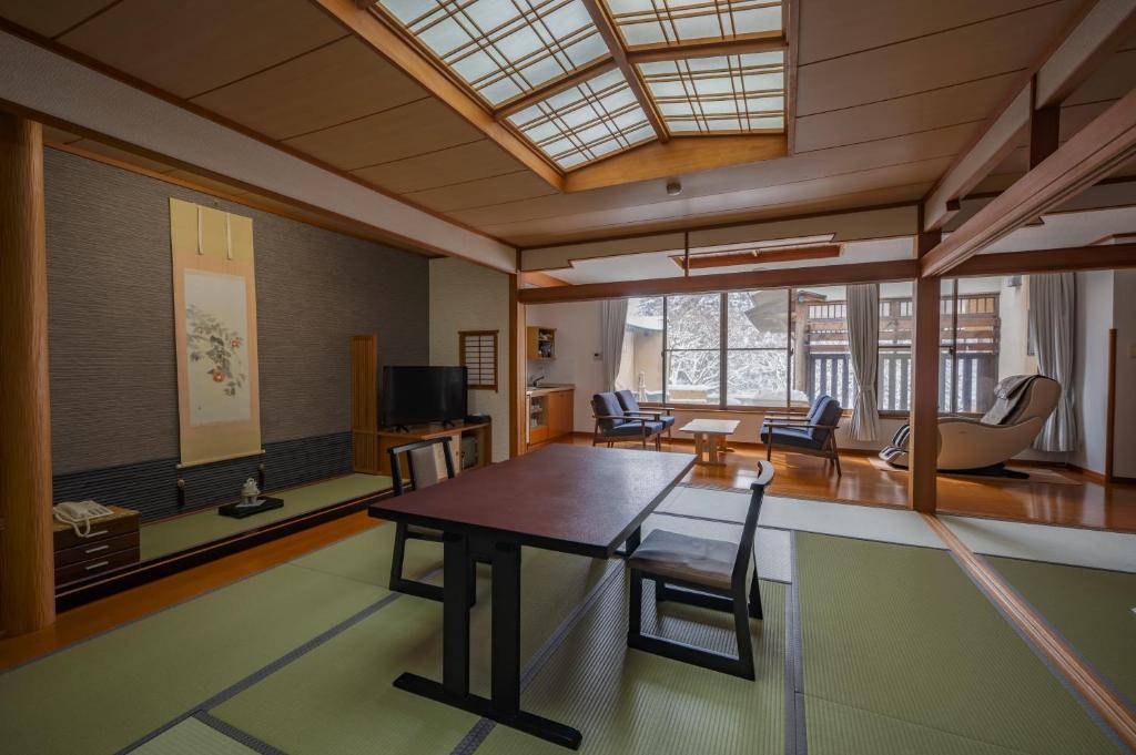 un salon avec une table et des chaises en bois dans l'établissement Seifutei, à Inawashiro