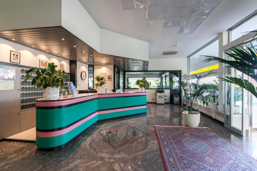 un hall d'entrée avec un comptoir coloré dans un bâtiment dans l'établissement Hotel Cormoran, à Cattolica 110 autres photos