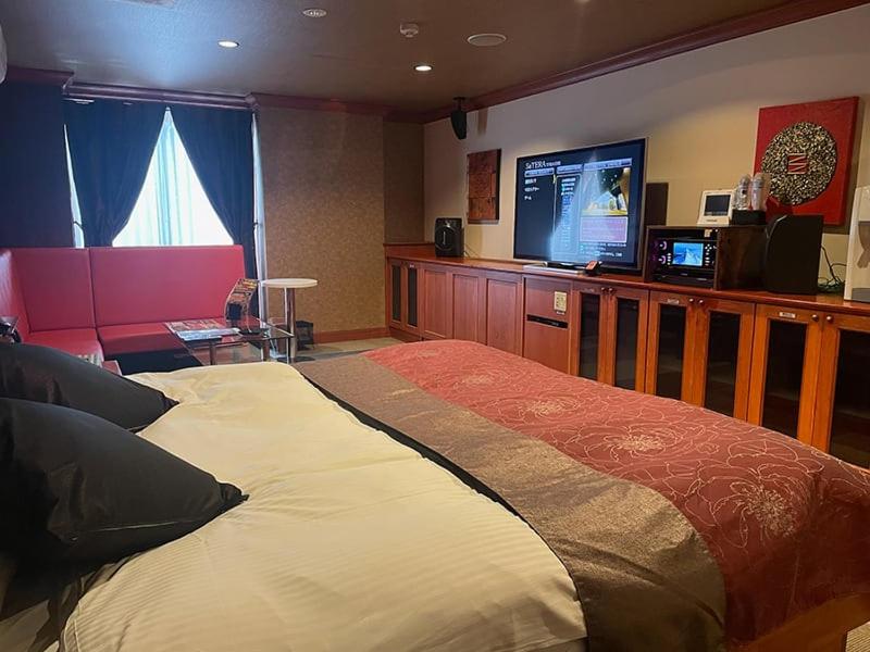 une chambre avec un grand lit et une télévision à écran plat dans l'établissement ウォーターゲート岐阜 A Japanese adult-oriented hotel, à Gifu