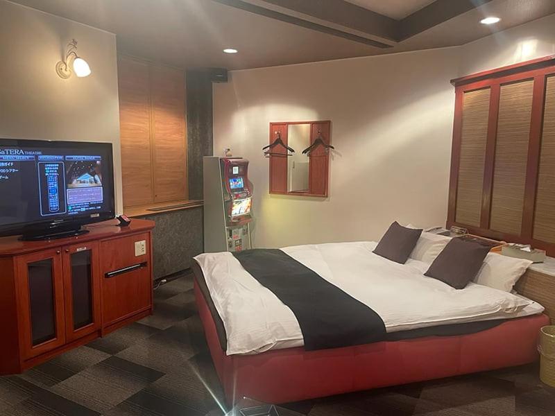 une chambre avec un lit et une télévision à écran plat dans l'établissement ウォーターゲート岐阜 A Japanese adult-oriented hotel, à Gifu