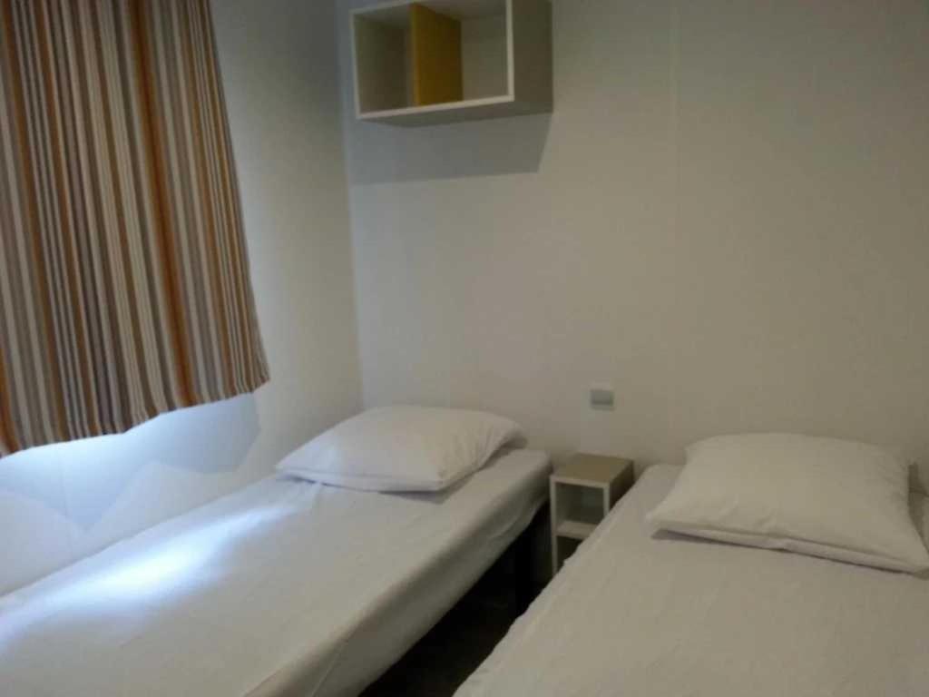 deux lits jumeaux dans une chambre avec fenêtre dans l'établissement Camping 4 étoiles - Piscine - ef00ai, à Avignon 18 autres photos