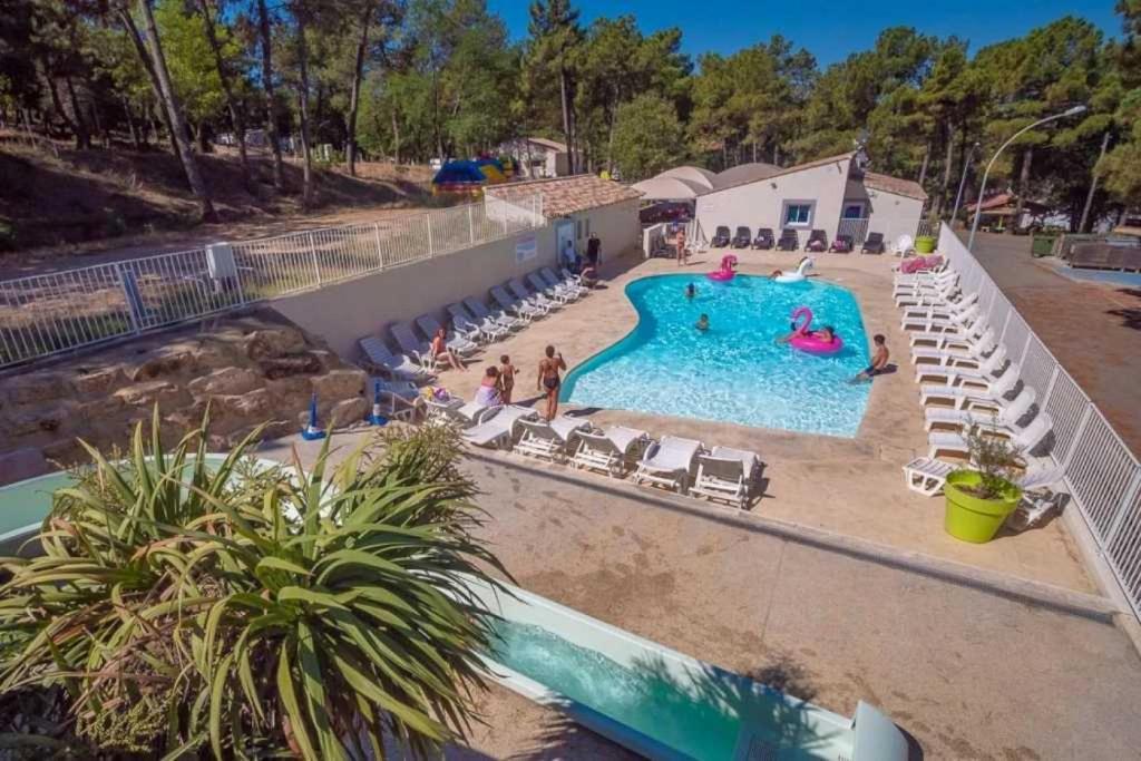 - une piscine dans un complexe avec des chaises et des personnes dans l'établissement Camping 3 étoiles - Piscine - eebeae, à Mondragon