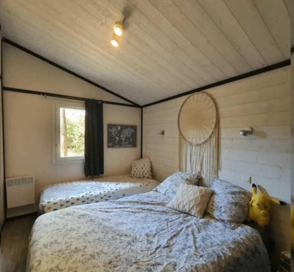 une chambre avec deux lits et une grande fenêtre dans l'établissement Camping 4 étoiles - Piscine - ccafgbh, à Saint-Hilaire-de-Riez