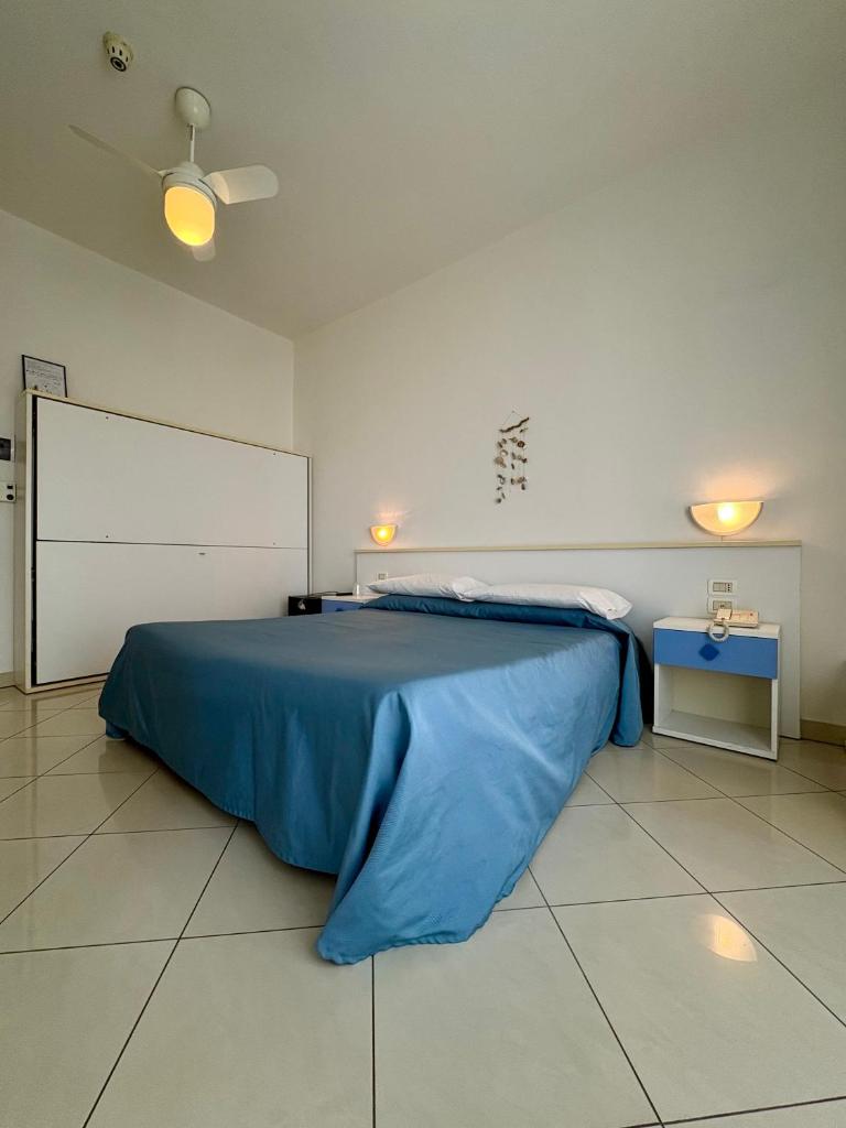 une chambre avec un grand lit avec une couverture bleue dans l'établissement Hotel Fortuna, à Chioggia 17 autres photos