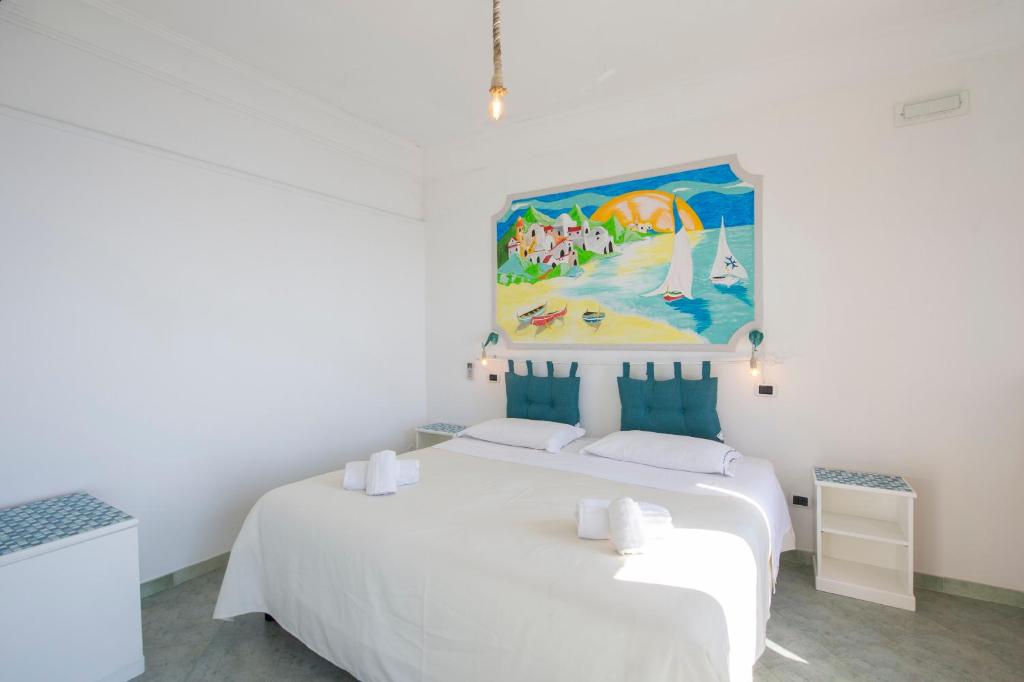 une chambre avec un lit blanc avec un tableau sur le mur dans l'établissement Exclusive villa on the Amalfi coast, 300 steps from the road, à Amalfi