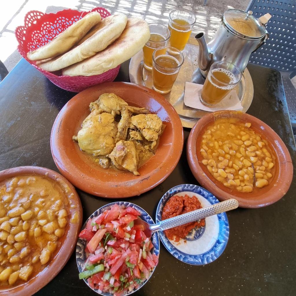 une table surmontée d'assiettes de nourriture et de bols de haricots dans l'établissement Riad Dar Jules, à Marrakech