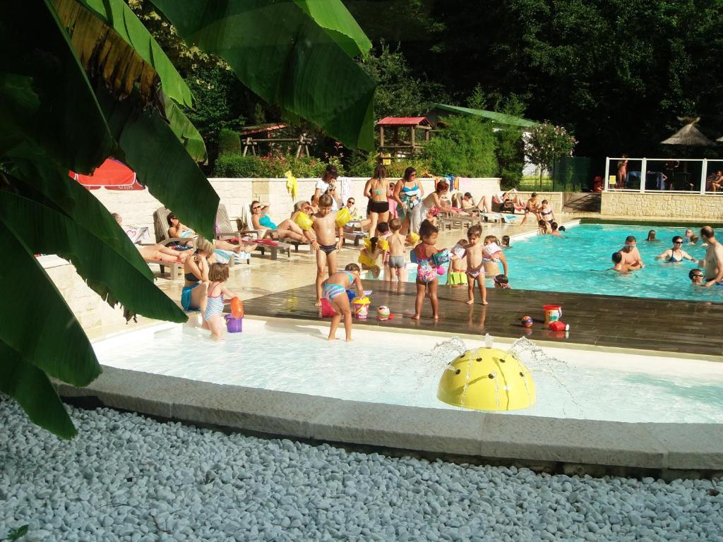 un groupe de personnes dans une piscine dans l'établissement Camping Les Sources, à Saint-Jean-du-Gard