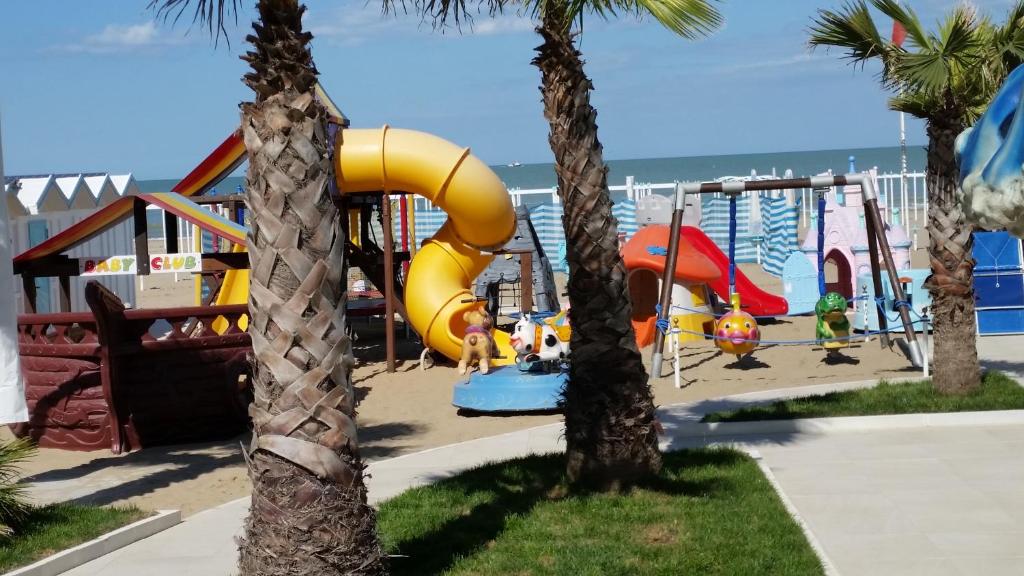 une aire de jeux à la plage avec des palmiers dans l'établissement Hotel Tosi, à Riccione