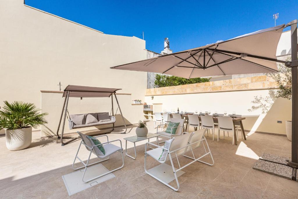 un patio avec une table, des chaises et un parasol dans l'établissement Villa Noemi Private Pool by HDSalento, à Leuca