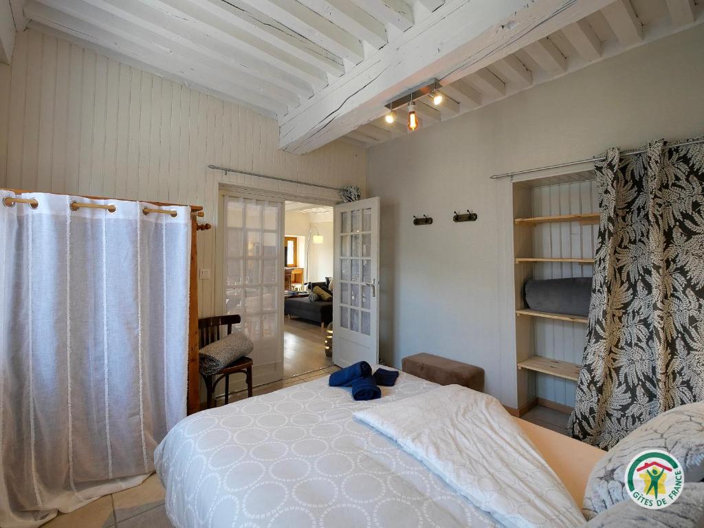 - une chambre avec un lit blanc et un salon dans l'établissement "La bâtisse des prés", à Puy-Saint-Vincent