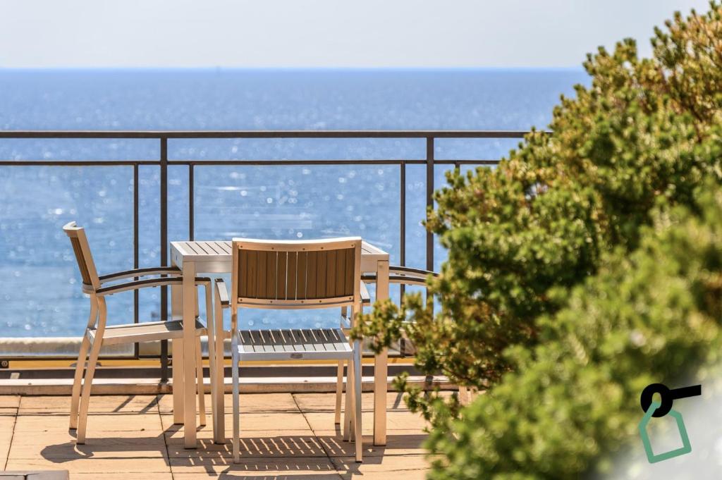 deux chaises et une table sur un balcon avec l'océan dans l'établissement HOTIDAY Room Collection - Alassio Centro, à Alassio