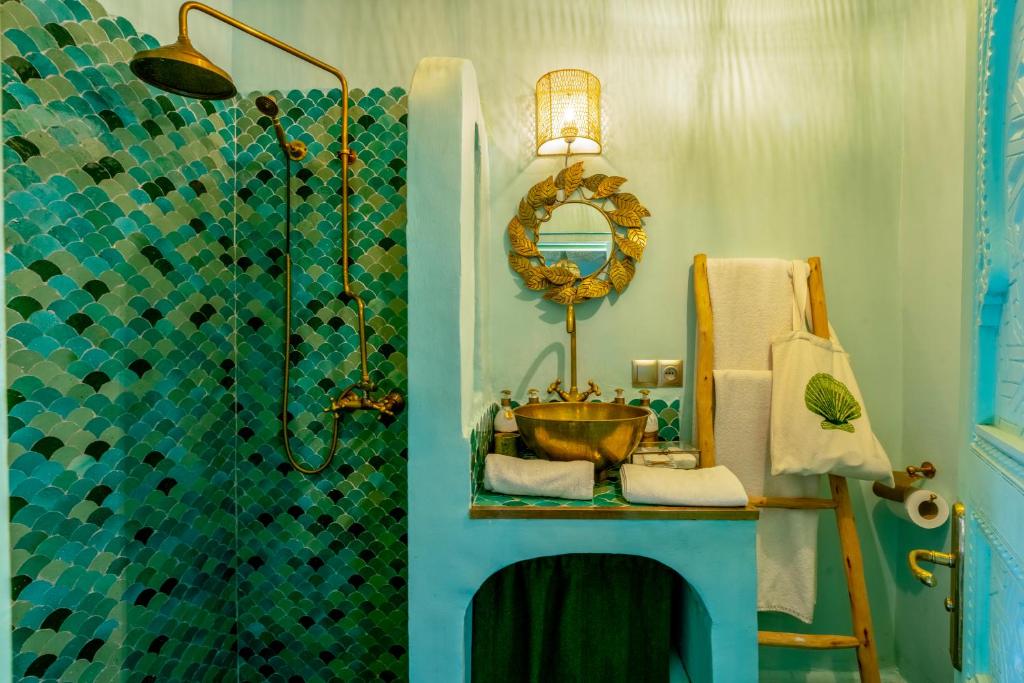 une salle de bain avec une douche avec un lavabo et un miroir dans l'établissement Riad Stella Cadente Marrakech, à Marrakech
