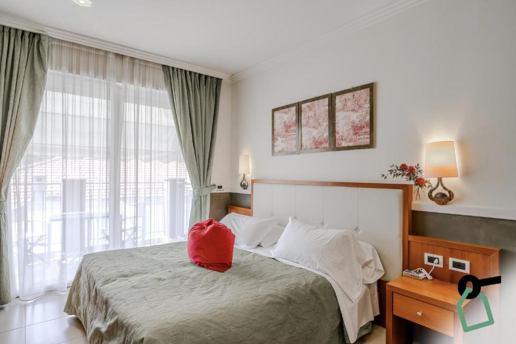 - une chambre avec un lit doté d'un sac rouge dans l'établissement HOTIDAY Room Collection - Alassio Centro, à Alassio
