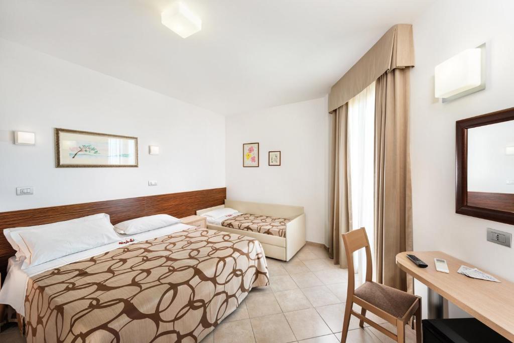 une chambre d'hôtel avec un lit et un bureau dans l'établissement Hotel Fenix, à San Benedetto del Tronto