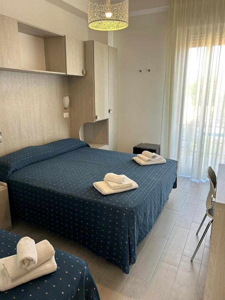 une chambre avec deux lits avec des serviettes dessus dans l'établissement Hotel Concorde, à Bellaria-Igea Marina