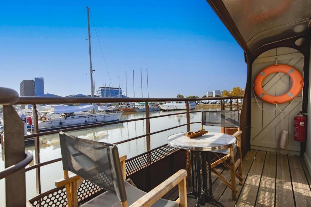 d'un balcon avec une table et une vue sur le port. dans l'établissement Superbe Péniche En Centre Ville, à Bordeaux