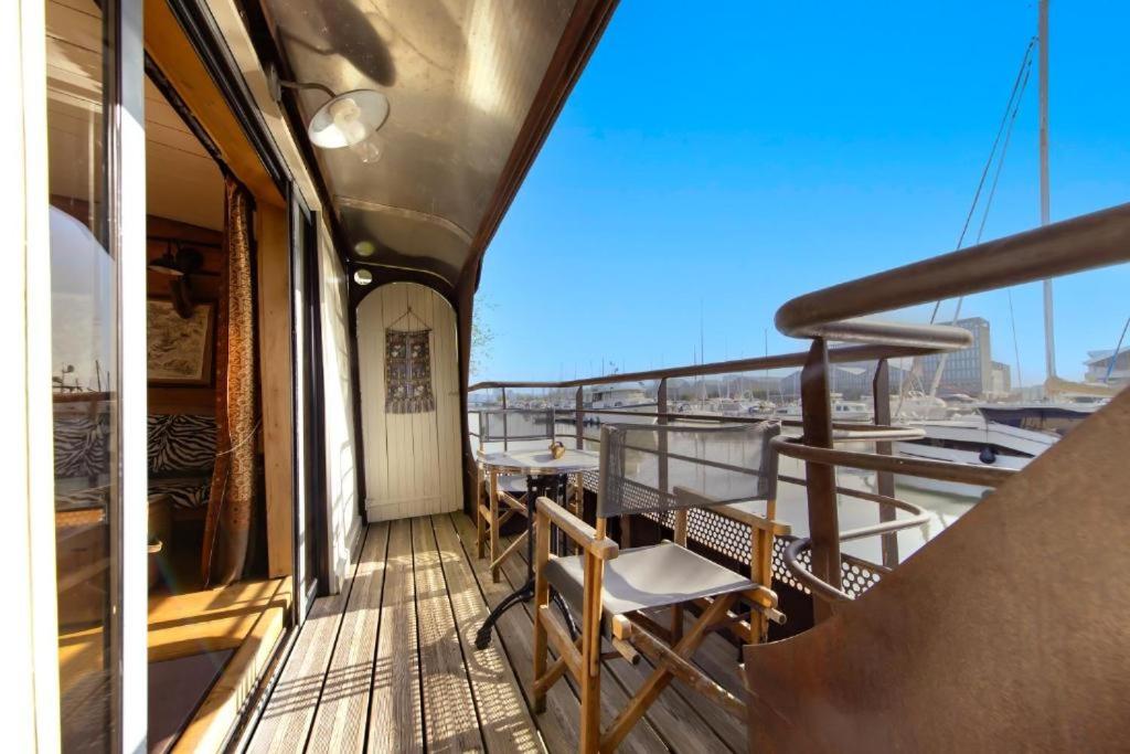 un balcon sur un bateau avec tables et chaises dans l'établissement Superbe Péniche En Centre Ville, à Bordeaux